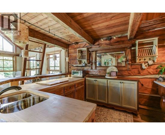 A kitchen with wooden cabinets and a wooden ceiling.