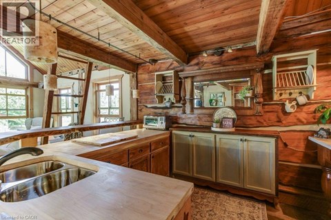 A kitchen with wooden cabinets and a wooden ceiling.
