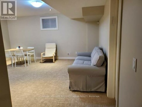 A living room with a couch, chairs, and a dining table.