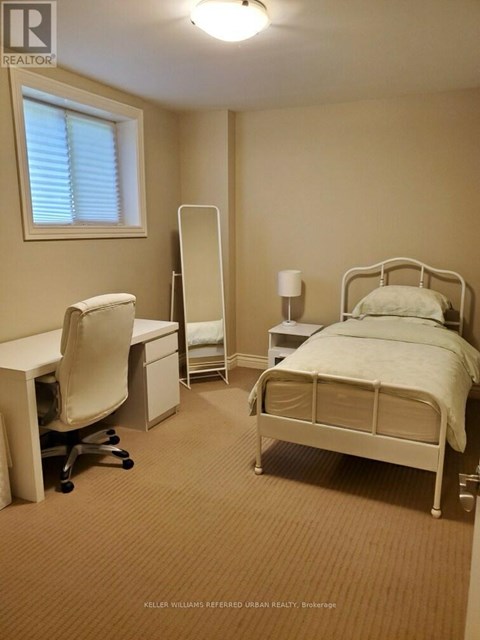 A bedroom with a bed, desk, and chair.