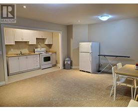 A kitchen with white cabinets and a refrigerator.