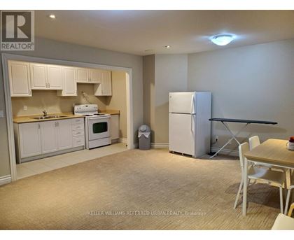 A kitchen with white cabinets and a refrigerator.