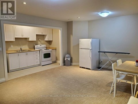 A kitchen with white cabinets and a refrigerator.
