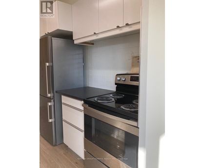 A kitchen with a stove and a refrigerator.