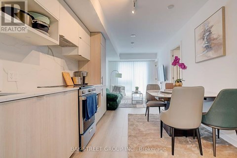 A modern kitchen with a dining area in the background.