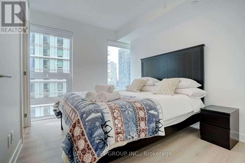 A bedroom with a large bed and a view of a city skyline.