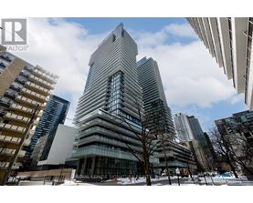 A tall building with a unique design stands out in a cityscape.