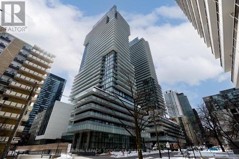 A tall building with a unique design stands out in a cityscape.