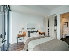 A bedroom with a large bed and a painting on the wall.