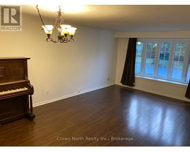 A room with a piano and a chandelier.