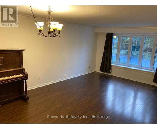 A room with a piano and a chandelier.