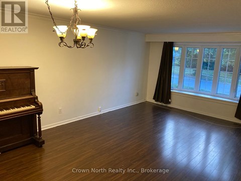 A room with a piano and a chandelier.