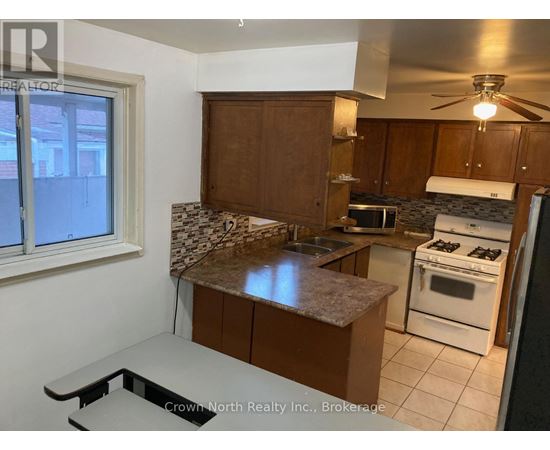 A kitchen with white appliances and brown cabinets.