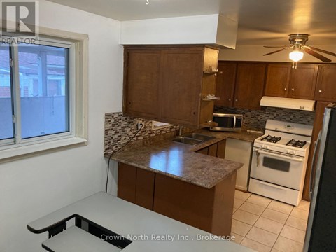 A kitchen with white appliances and brown cabinets.
