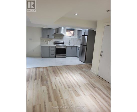 A kitchen with wooden floors and a white door.
