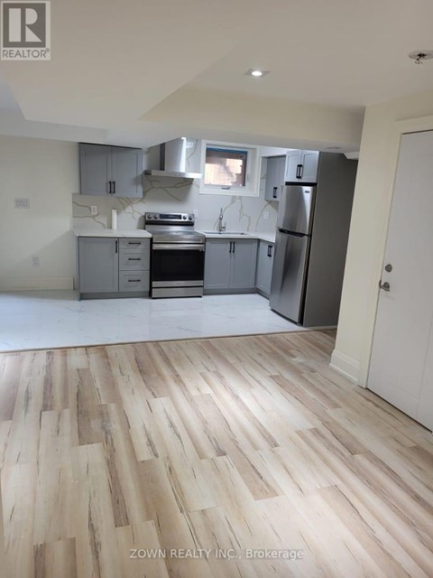 A kitchen with wooden floors and a white door.