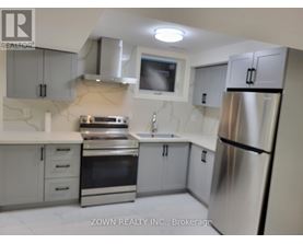 A kitchen with a refrigerator, oven, and sink.