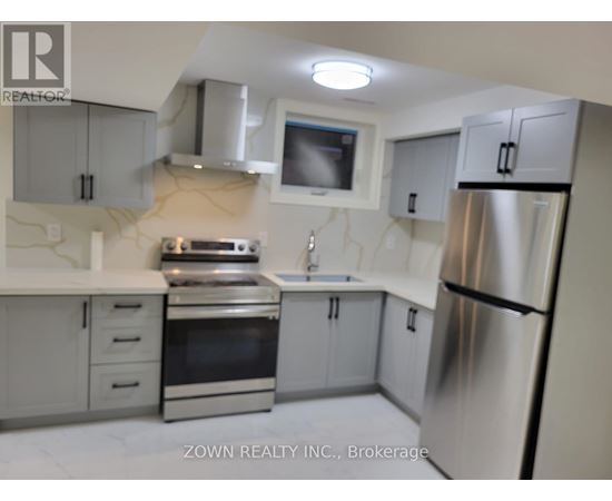 A kitchen with a refrigerator, oven, and sink.