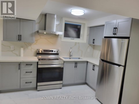 A kitchen with a refrigerator, oven, and sink.