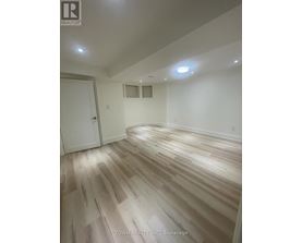 A room with wooden flooring and a white door.