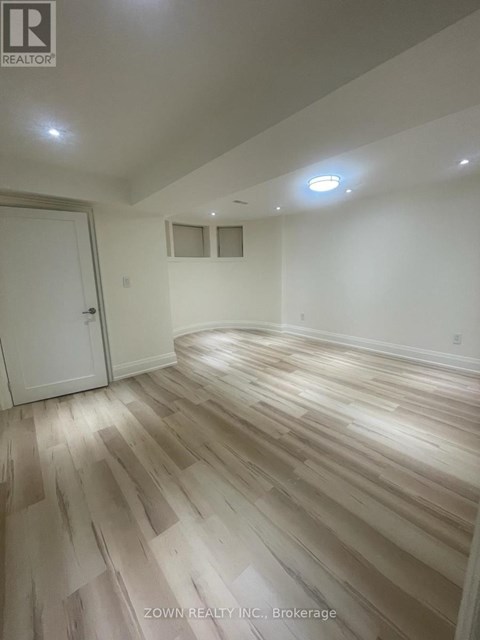 A room with wooden flooring and a white door.