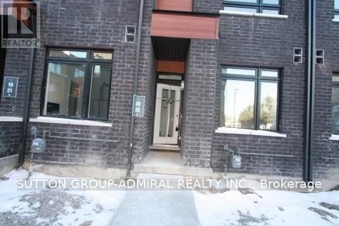 A brick building with a red awning and a sign that says Sutton Group-Admiral Realty Inc Brokerage.