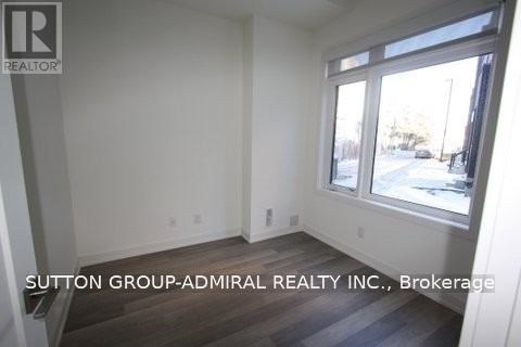 A room with a window and a sign that says Sutton Group-Admiral Realty Inc., Brokerage.