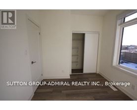 A room with a door and a window with Sutton Group-Admiral Realty Inc., Brokerage written on the wall.