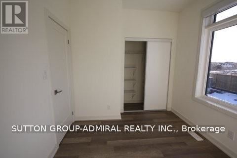 A room with a door and a window with Sutton Group-Admiral Realty Inc., Brokerage written on the wall.