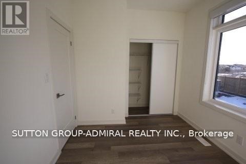 A room with a door and a window with Sutton Group-Admiral Realty Inc., Brokerage written on the wall.