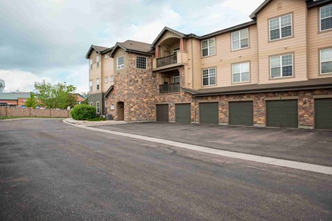 A large apartment building with a parking lot in front.