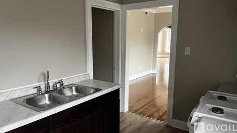 A kitchen with a sink and a stove top oven.