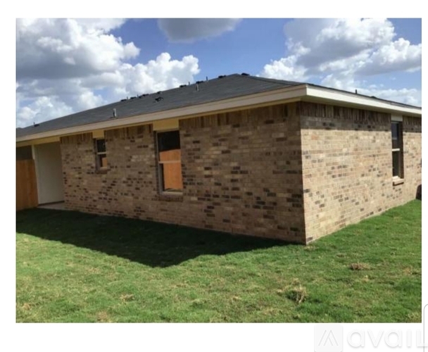 A house with a brown brick exterior and a grey roof.