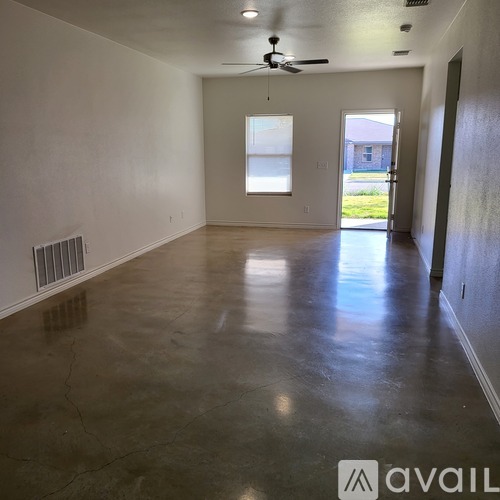 A spacious room with a ceiling fan and a window.