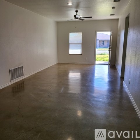 A spacious room with a ceiling fan and a window.