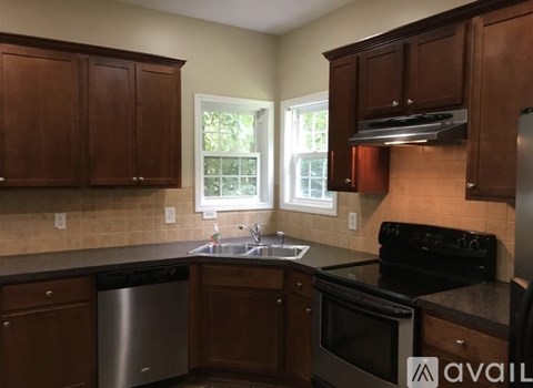 A kitchen with wooden cabinets and a black stove top oven.