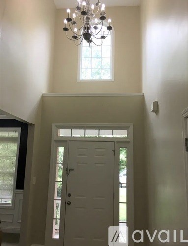 A white door with a glass window is in the middle of a hallway.