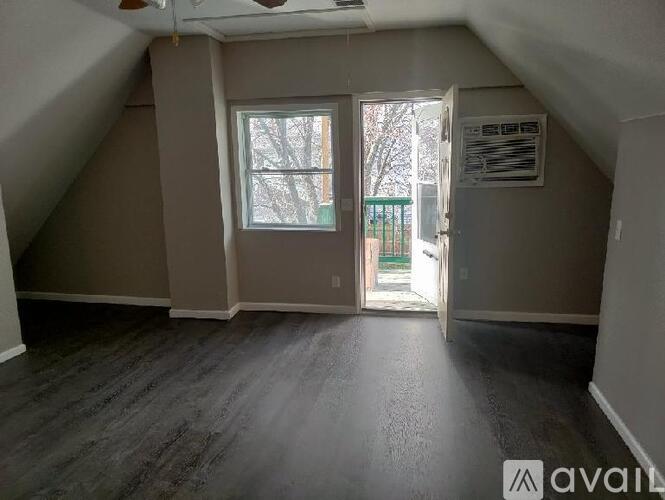 A room with a window and a door leading outside.