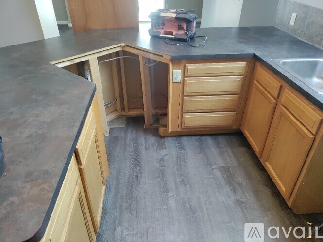 A kitchen with wooden cabinets and a black countertop.
