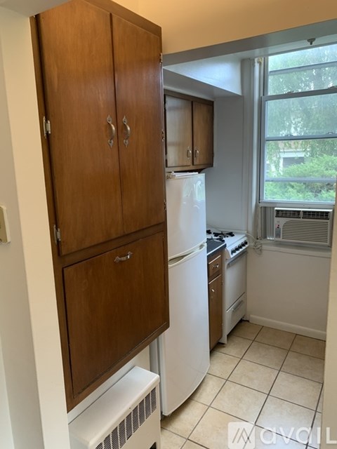 A kitchen with a white refrigerator and wooden cabinets.