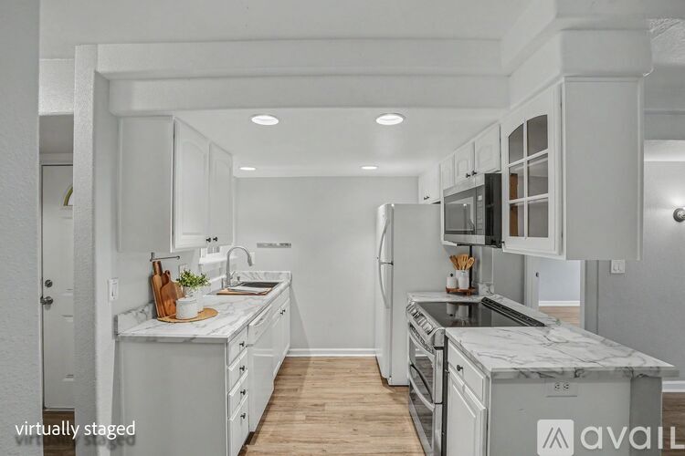 A kitchen with white cabinets and appliances.