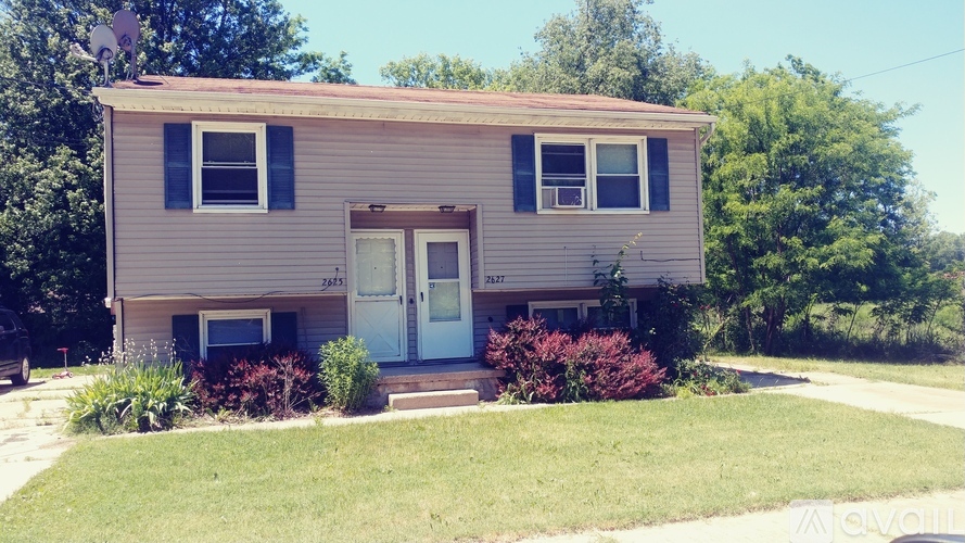 A two-story house with a white door and windows.