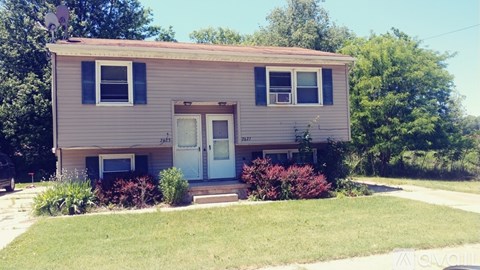 A two-story house with a white door and windows.