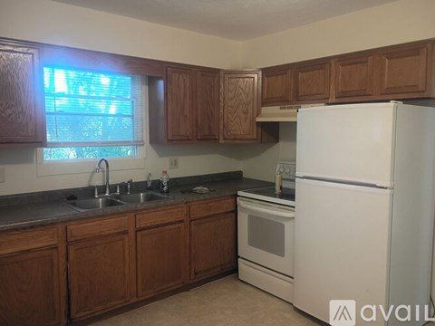 A kitchen with wooden cabinets and a white refrigerator.