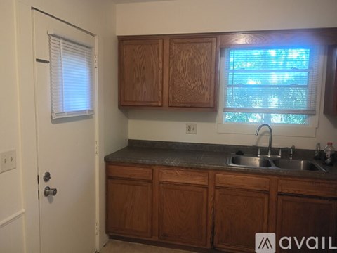 A kitchen with wooden cabinets and a granite countertop.