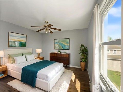 A bedroom with a large bed and a ceiling fan.