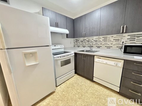 A kitchen with a white fridge, stove, and dishwasher.