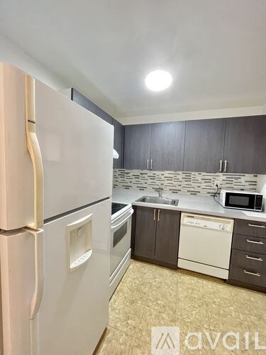 A kitchen with a white fridge and a white dishwasher.