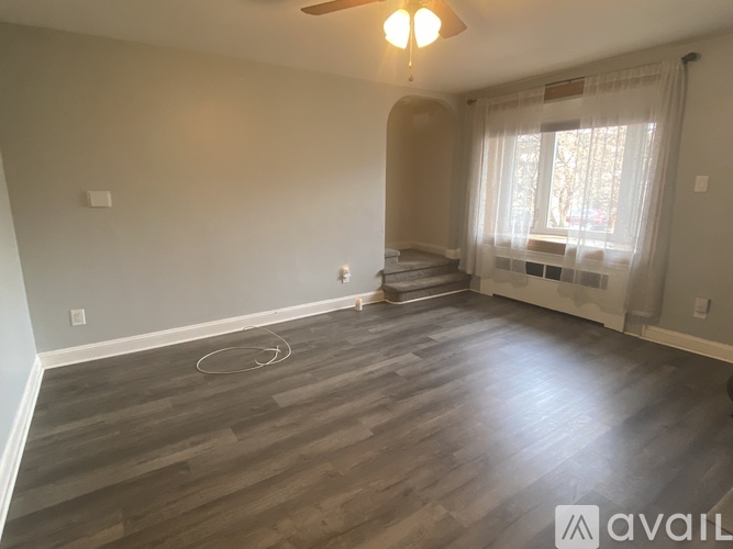 A room with wooden flooring and a ceiling fan.