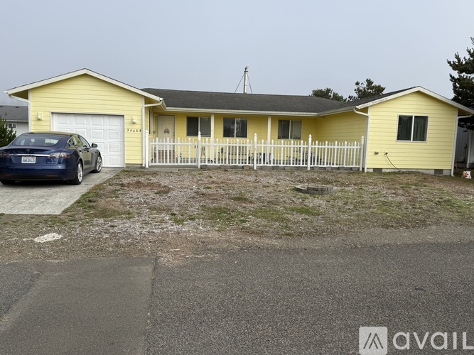 A yellow house with a blue car parked in front.
